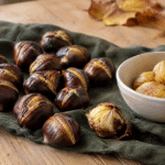 Castagne arrostite con buccia incisa e polpa dorata su un canovaccio