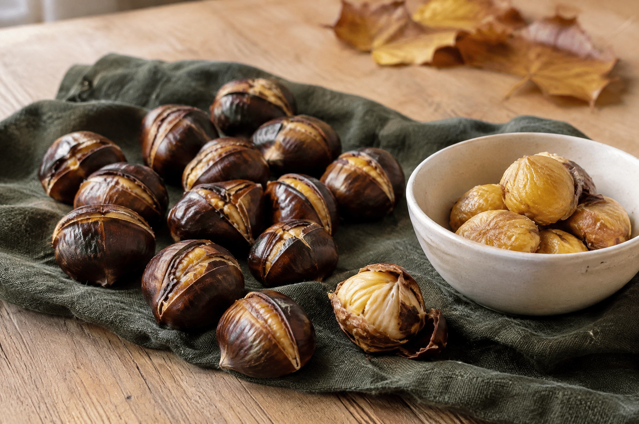 Castagne arrostite con buccia incisa e polpa dorata su un canovaccio